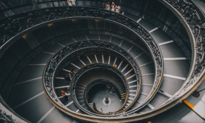 a spiral staircase in a building with people walking down it